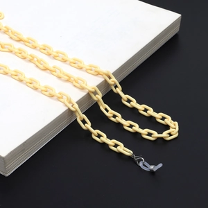 Detailed macro view of cream yellow acrylic eyewear chain with lobster clasps