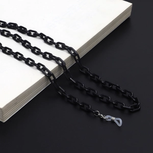 Detail shot of black acrylic eyeglass chain with silicone loops on a book surface
