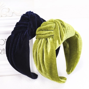 Detail of navy and green velvet knotted headbands displayed against a white photo frame