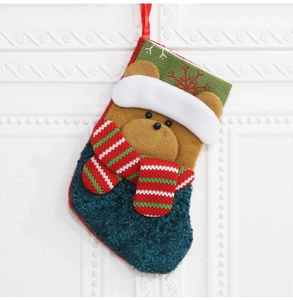 Détail d'une chaussette de Noël en peluche verte avec ours en 3D et écharpe rayée