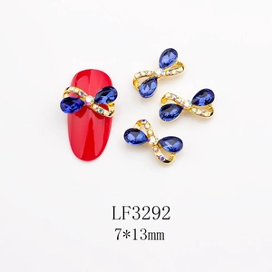 Dettaglio di ciondolo per unghie a fiocco in metallo con strass blu e misura 7x13mm
