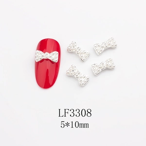 Dettaglio di ciondoli per unghie a fiocco con perle 5x10mm su manicure rossa