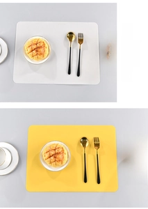 Detail of rectangular silicone placemats in white and yellow with a modern Nordic style