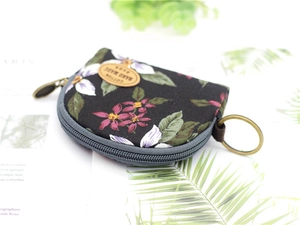 Detail of floral canvas coin purse with zipper closure and bronze metal key ring