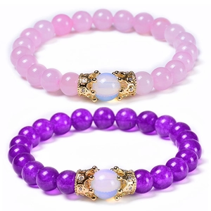 Detailed macro of pink and purple natural stone bracelets with golden zircon crown charms