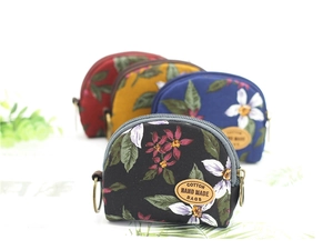 Macro view of semi-circular floral cotton coin purses with vintage patterns and leather tags