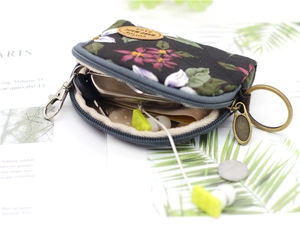 Detail view of floral canvas coin purse featuring metal keychain and earphone storage