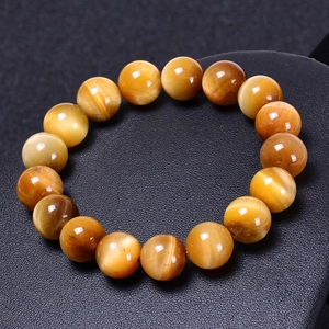 Bracciale di perle occhio di tigre dorato naturale con lucentezza su supporto nero