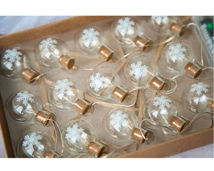 Close-up of glass bulb Christmas lights with snowflake patterns and cork stoppers