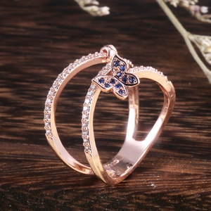 Macro shot of rose gold double-layer butterfly ring with blue and white zircons