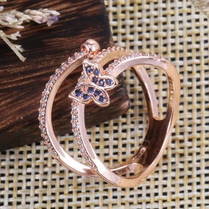Macro view of rose gold butterfly ring with blue zircon stones and micro-pave crystals