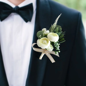 Dettaglio di un'elegante boutonnière color crema su un abito da sposo nero