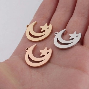 Hollow moon and star charms in gold, silver, and rose gold finishes on a palm