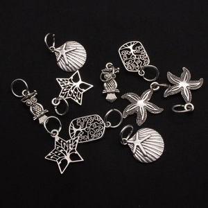 Detailed close-up of vintage silver alloy charms featuring starfish, shells, and owls