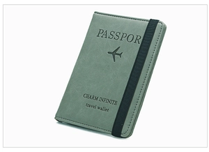 Detailed view of grey PU leather passport cover with elastic strap and embossed lettering