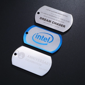 Three engraved stainless steel dog tag pendants in silver and blue on dark background