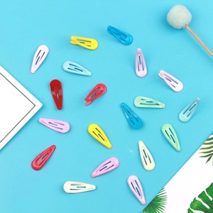 Flat lay of colorful 5cm metal snap hair clips for kids on a blue tropical background