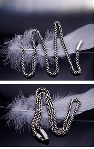 Macro detail of silver titanium steel wheat chain featuring antique finish and clasp
