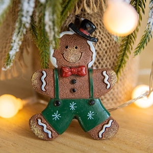 Cute 3D gingerbread man fridge magnet with festive Christmas tree and fairy lights background