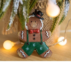 Detail of a 3D resin Gingerbread Man fridge magnet with festive bow and overalls