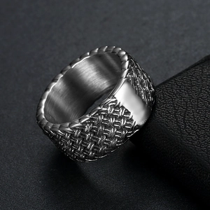 Detail of silver stainless steel ring featuring woven texture and brushed inner finish