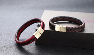 Detail of woven leather bracelets with gold magnetic metal clasps in black and red hues