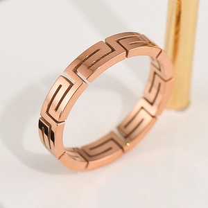 Polished rose gold stainless steel ring with Greek key fret pattern in minimalist style