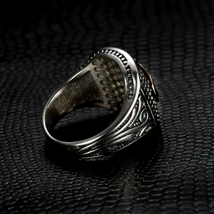 Macro shot of silver vintage crown ring with engraved wave patterns and punk style details