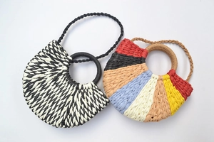 Detail of colorful and geometric woven straw handbags with circular top handles