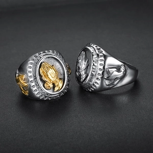 Detailed close-up of retro praying hands and peace dove relief on stainless steel rings