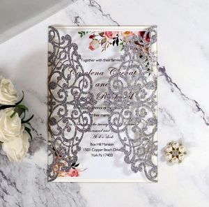 Detail of silver glitter laser-cut wedding invitation with elegant floral insert cards