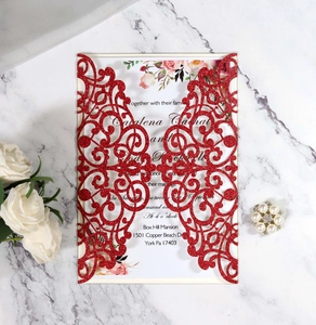 Detail showing laser cut red glitter wedding invitation with white insert on marble