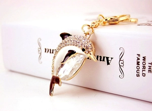 Detailed view of dolphin keychain featuring white enamel and crystal embellishments