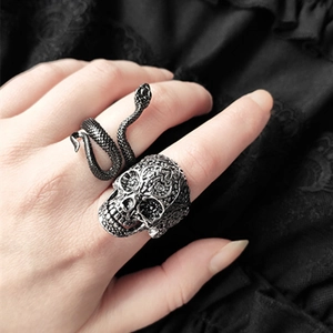 Gothic silver skull and black snake wrap ring set shown on hand with lace backdrop