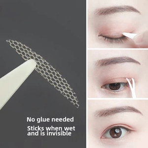 Detailed macro view of water-activated invisible lace eyelid tape with applicator tools