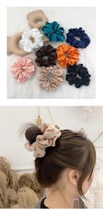 Detailed view of assorted satin silk scrunchies with vibrant colors and elegant texture
