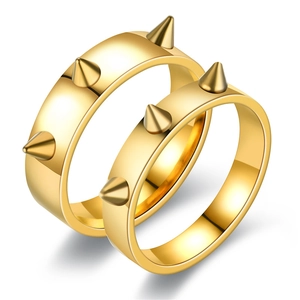 Detail van twee gouden punkringen met scherpe kegelspikes en een glanzende metalen afwerking