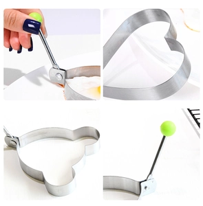 Detail of heart and bear shaped stainless steel egg rings with green handles