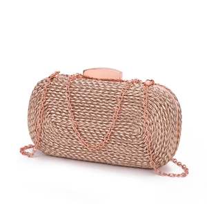Close-up of rose gold woven PU evening clutch with metallic texture and chain strap