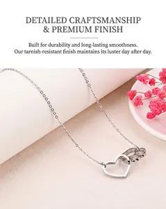Détail du collier en acier poli avec pendentifs en forme de cœur et de patte