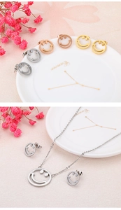 Parure de bijoux avec visage souriant en or, or rose et argent sur une assiette blanche