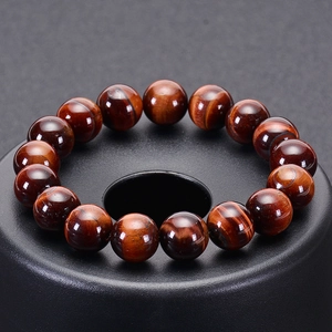 Natural red tiger eye gemstone bead bracelet with silky luster on a round display stand