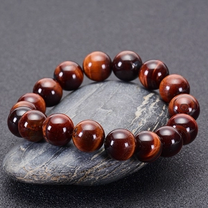 Macro view of natural red tiger eye stone bracelet beads with shimmering cat-eye effect