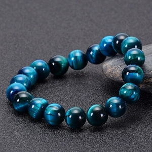Macro shot of blue tiger eye stone beads bracelet with glossy texture and cat-eye effect