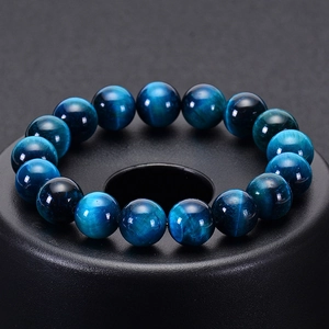 Macro shot of 16 natural blue tiger eye beads on a sleek black circular display base