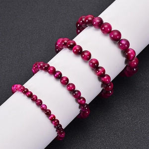 Three rows of rose red tiger eye stone beaded bracelets in different bead sizes on white stand