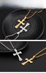 Macro detail of gold and silver cross pendants with vintage textures on twist chains