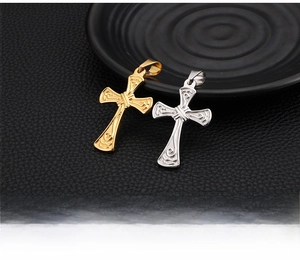 Detailed close-up of gold and silver cross pendants with baroque embossed floral patterns