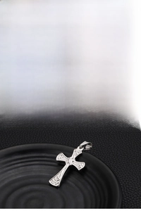 Detailed macro view of a silver stainless steel cross pendant with Celtic floral patterns