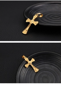 Macro shot of gold cross pendant with intricate embossed texture on leather surface